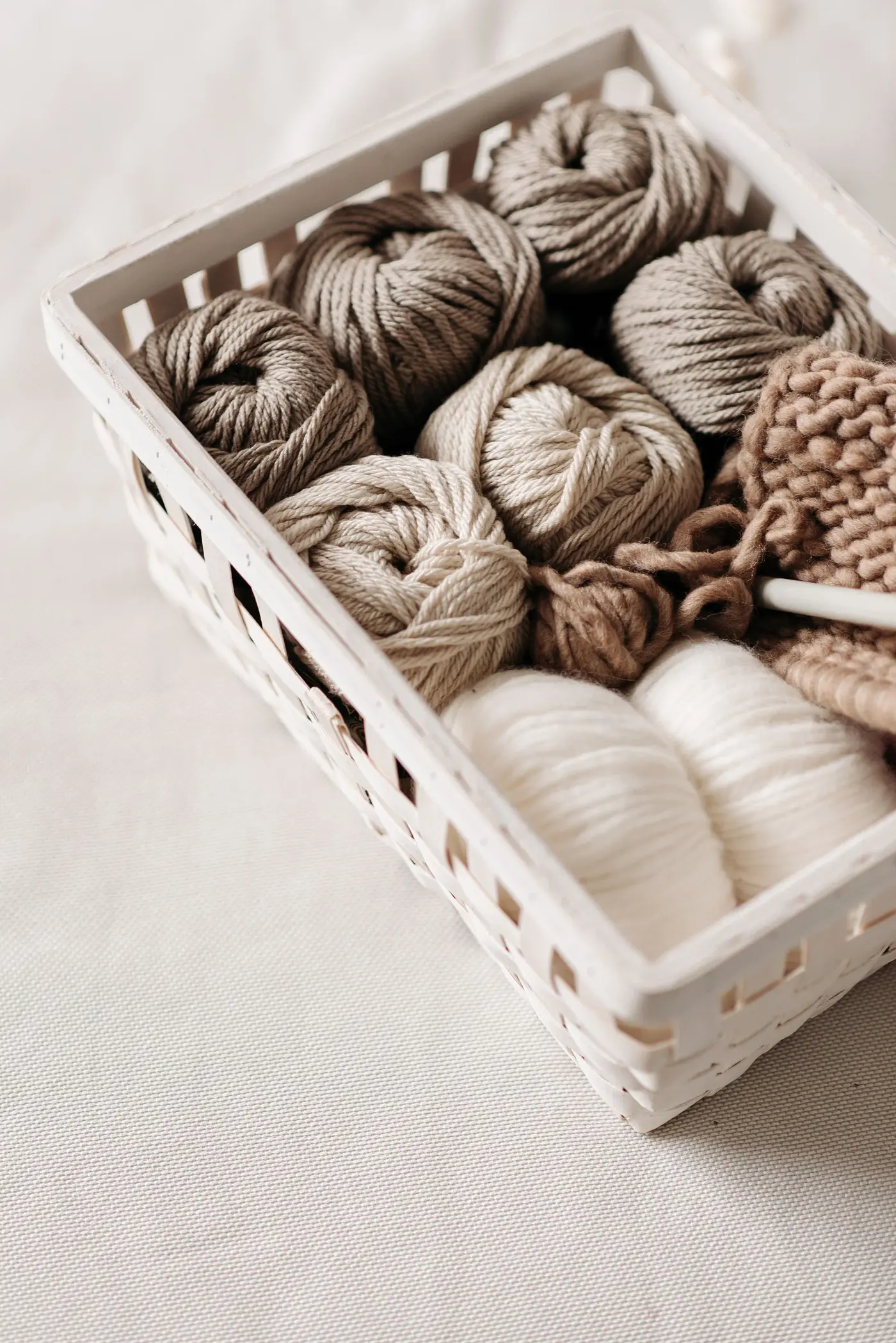 Basket of wool yarn balls in earthy tones